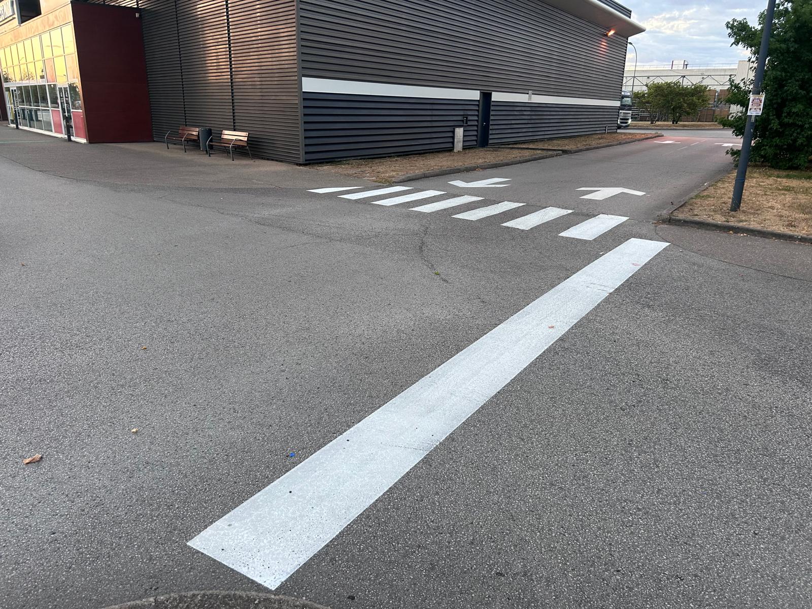 Ligne d'arrêt, passage piéton et flèches de direction sur une voie de circulation interne